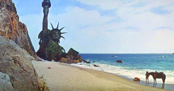 A beach with the Statue of Liberty bury up to her chest.