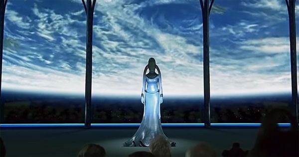 Full-body view of the Diva Plavalaguna standing onstage before a large viewing window, with a planet visible in the background.