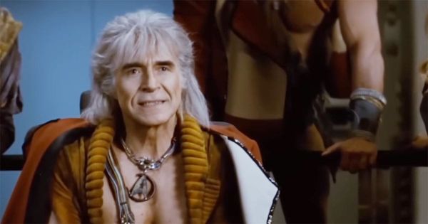 Khan Noonien Singh seated on the Reliant’s bridge, wearing a torn uniform and triumphant expression during battle.