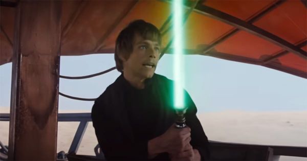 Luke Skywalker fighting aboard a desert skiff, lightsaber glowing in mid-swing.