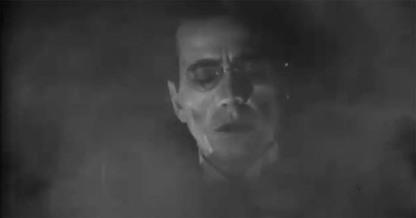 A pale scientist’s face appears through heavy mist in a dramatic scene from the classic film “The Return of Doctor X.”