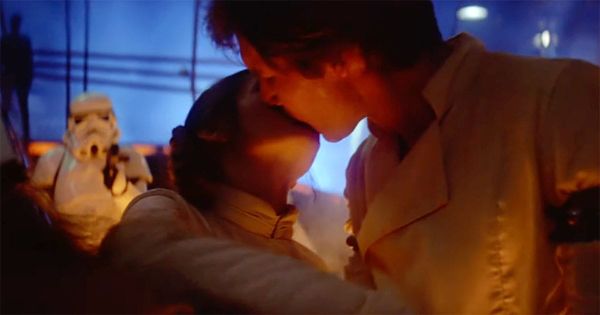 Han Solo and Princess Leia share a kiss as he prepares to be frozen in carbonite, surrounded by Imperial forces.