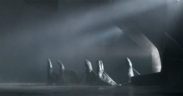 Several cloaked Bene Gesserit sisters process across a dark, misty chamber beneath angled white light.