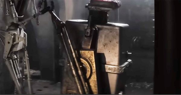 Upside-down Gonk Droid beside industrial machinery in a dark "Star Wars" corridor.