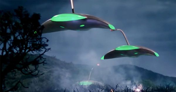 Martian war machines with glowing green domes advance through a dark, smoky landscape in "The War of the Worlds" (1953).