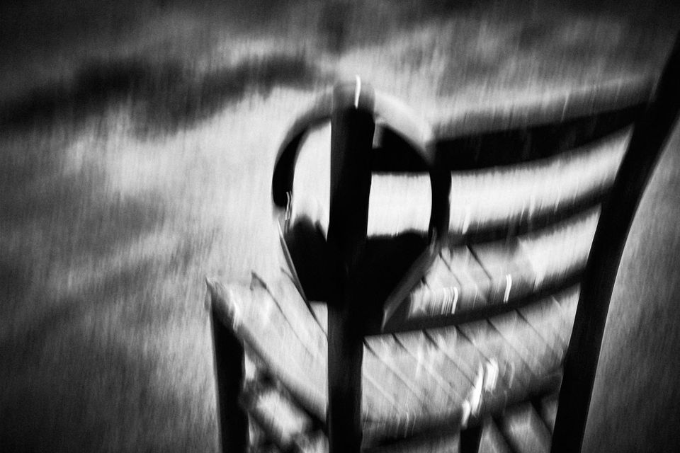Black and white photo of blurry chair with headphones on the bac. Migraine Unread original. 