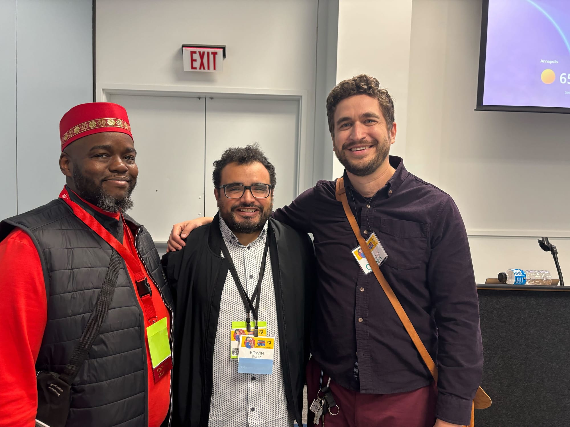 Cortly, Edwin, and Owen smiling and wearing MSEA union member and delegate badges.
