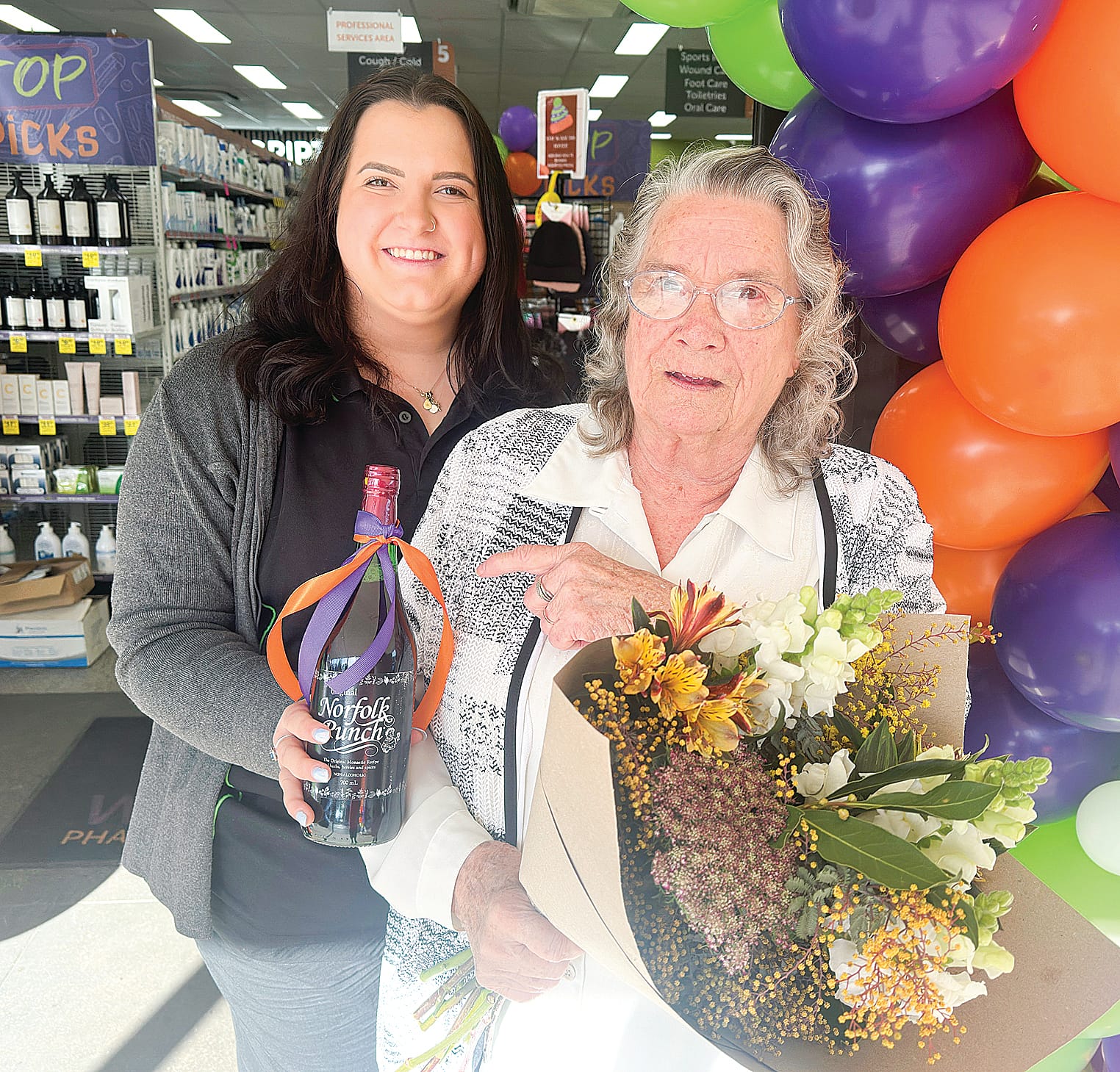 Regular customer and baker, Pat, is given flowers and wine for baking all the treats for the celebration at Mirboo North Pharmacy. ob08_2925