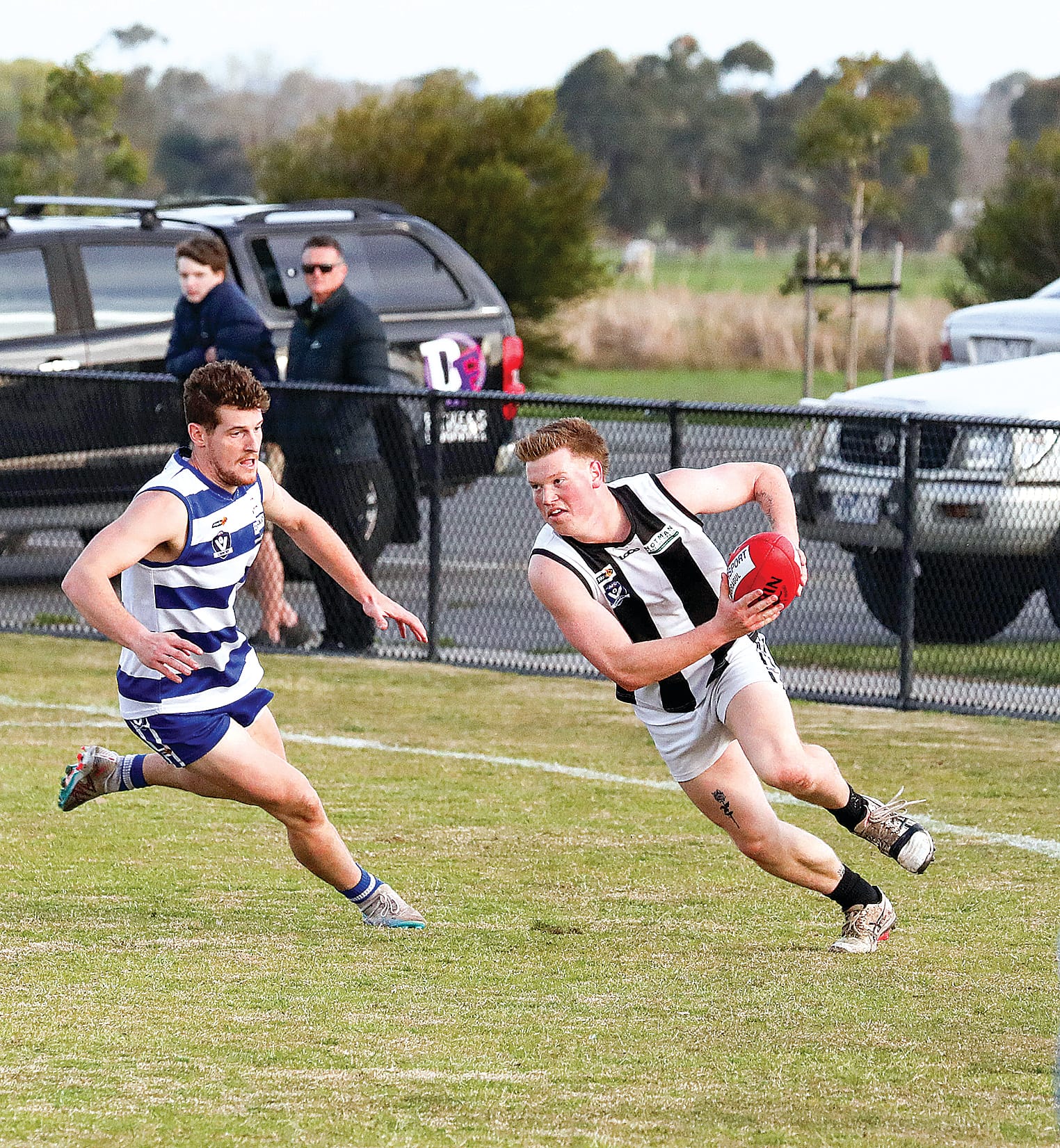 Poowong’s Zac Gray looks for options, pursued by Neerim South.