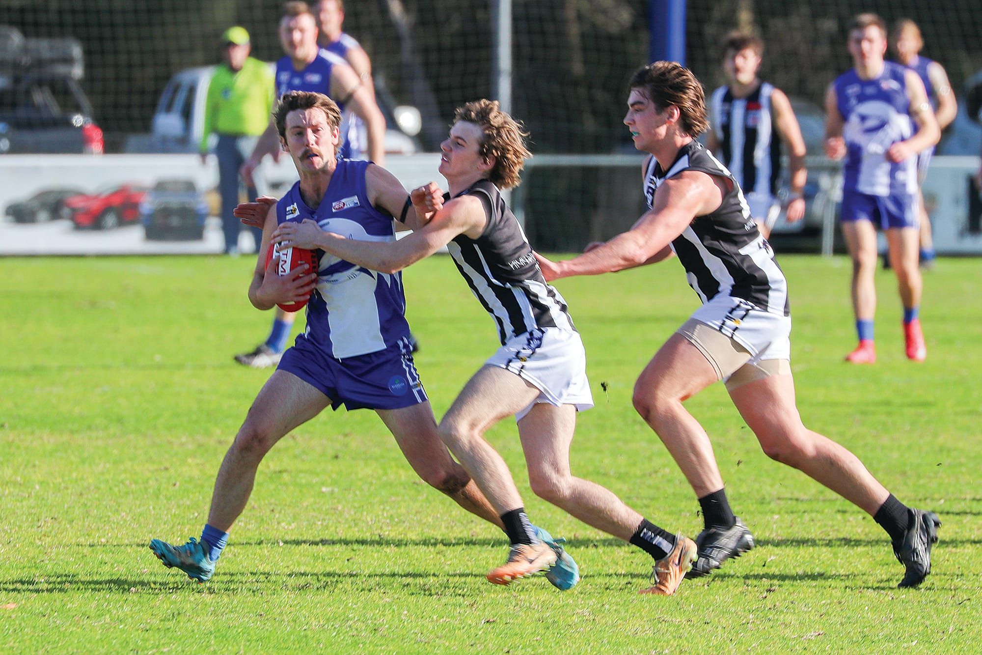 Ben Ellen fends off two Yinnar players in the contest. W27_2725