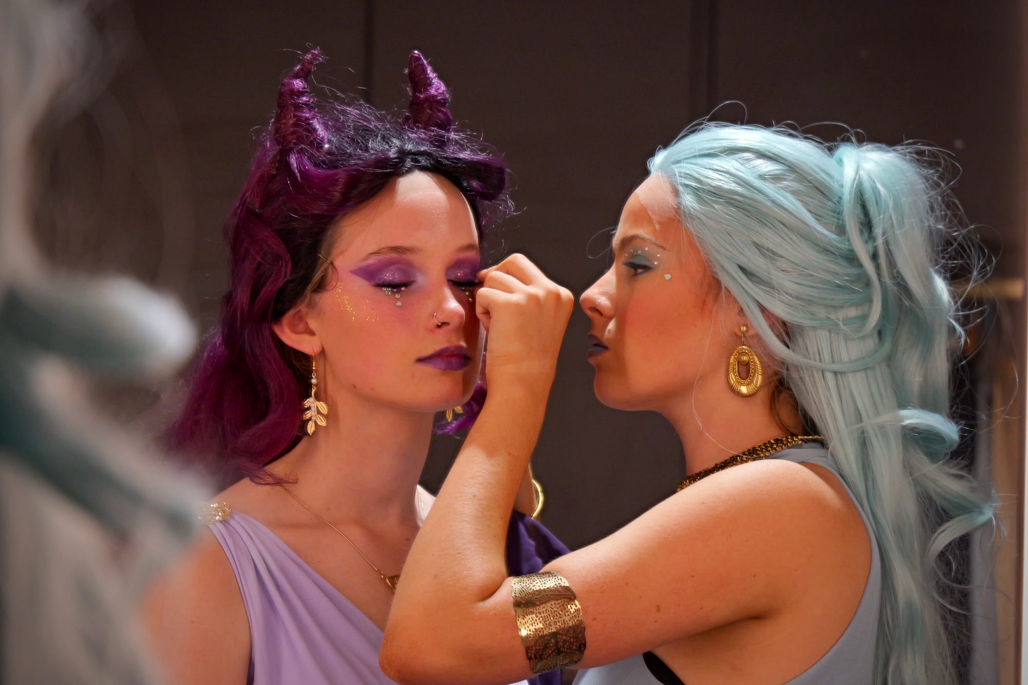 Nissa Campbell Walker, playing Melpomene, and Matilda Russell (Erato) practice their make-up application during rehearsals.