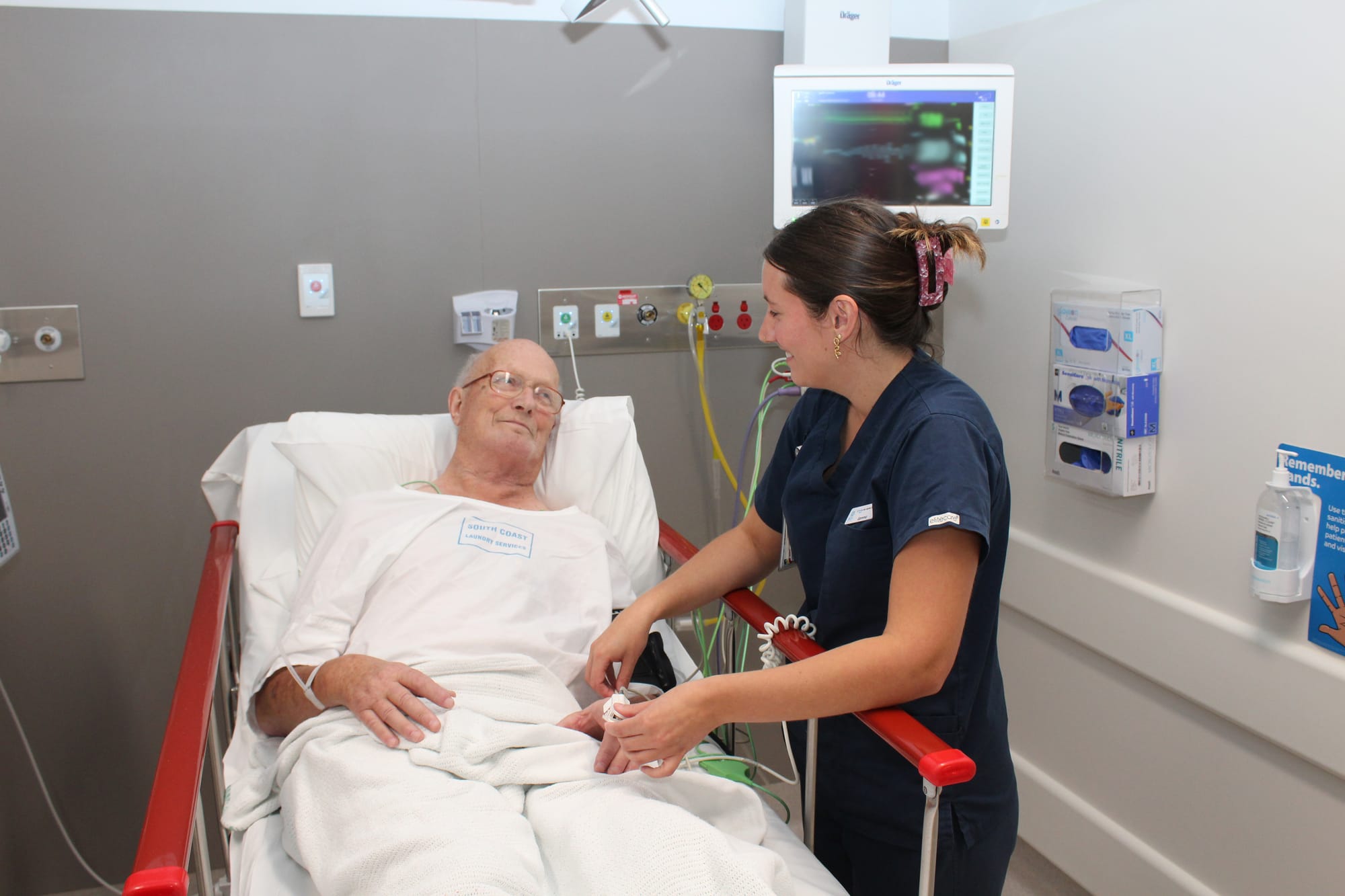 Emergency Department Registered Nurse Gemma Phillips monitors patient Geoff McKenzie.
