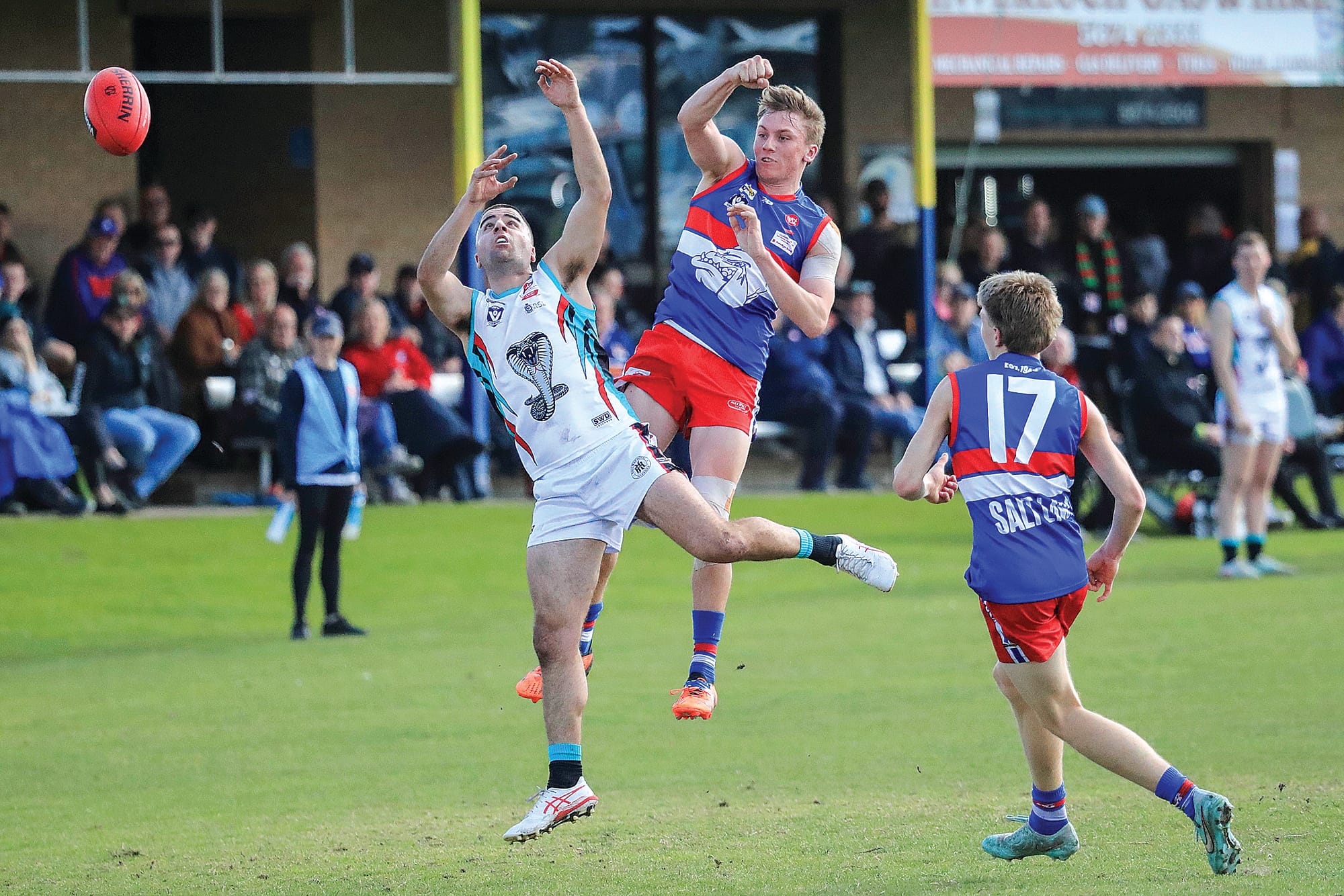 Phillip Island’s Max Walton smashes the ball with his fist out of the ruck. Photo: Carol Ratcliff.
