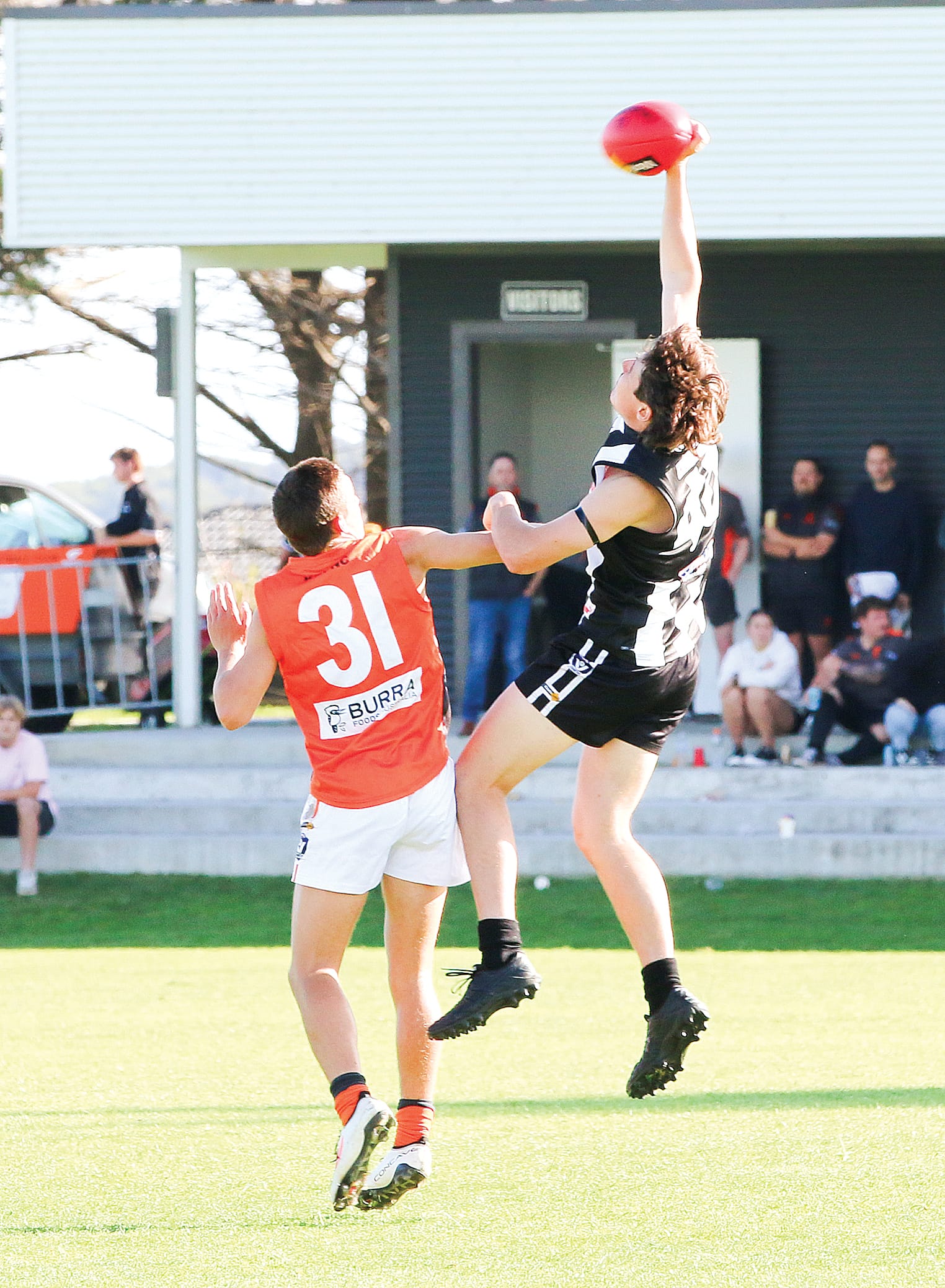 Magpie Fraser West punches the ball forwards against opposition Codie Anderson in the ANZAC clash at Dalyston Rec Reserve. C85_1824