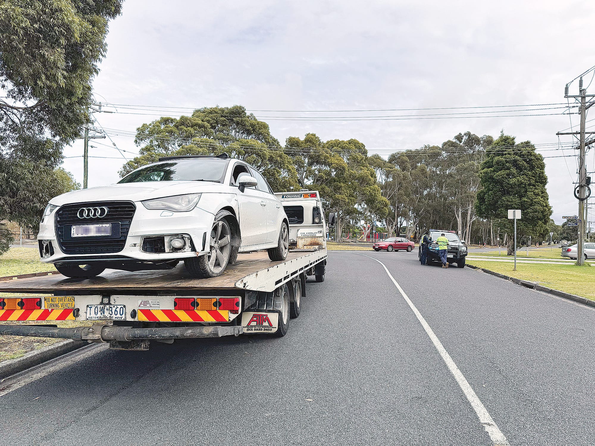 The white Audi could be seen on the back of a tow truck leaving the scene after colliding with the curb and closing the road for a period of time on Sunday morning.
