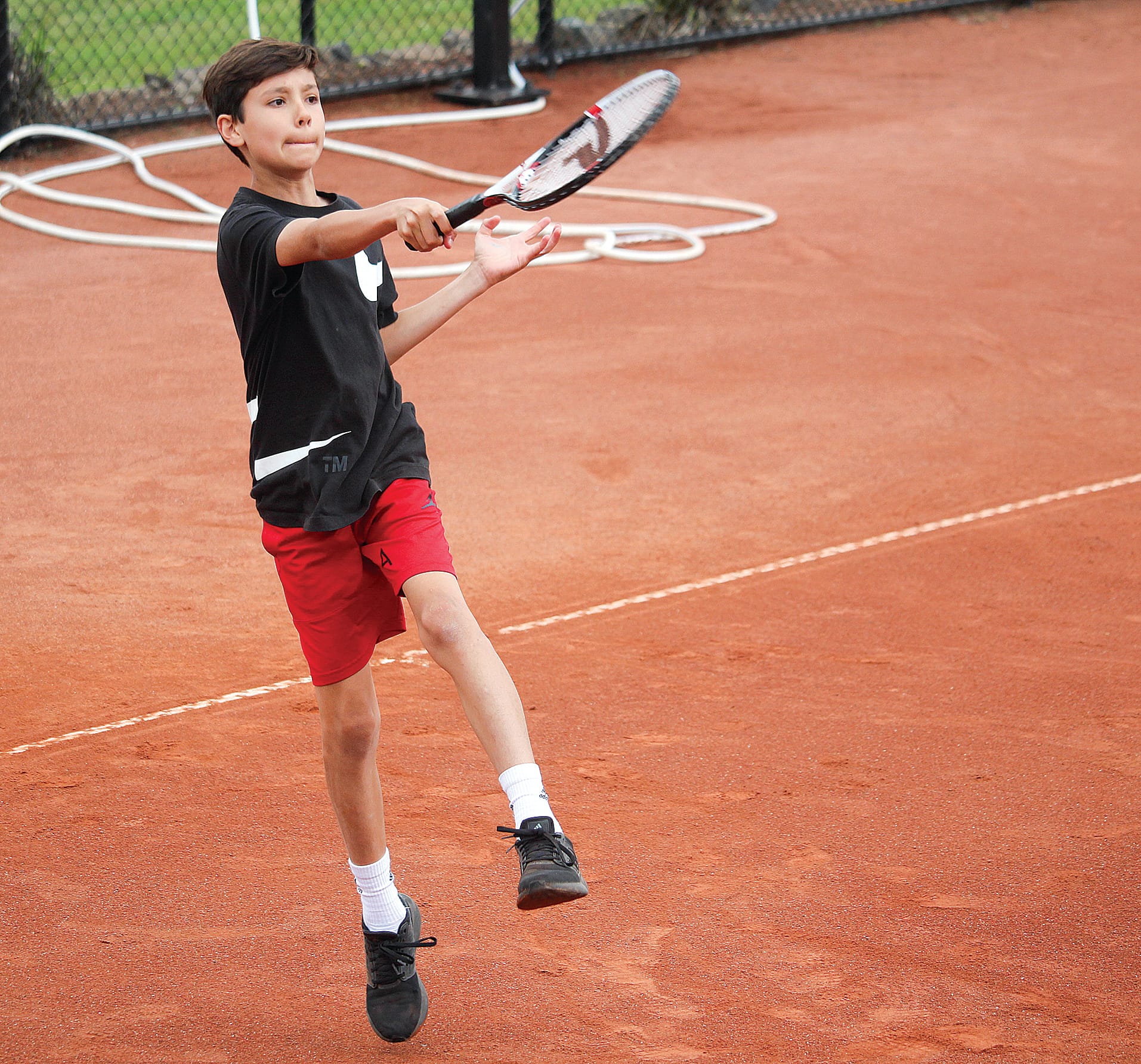 Local talent Ari Bogaert takes to the air to play a nice forehand on his home court. B07_0223