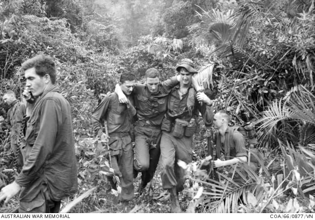 On October 8, 1966, 12 men of C Company, 5RAR were wounded - one seriously - when two booby-trapped grenades exploded. One of six men hit by shrapnel in the first detonation, Private David Riik, is assisted to a 'dust-off' chopper by Lance-Corporals Ron Shoebridge (left) and David 'Stretch' Bryan. Riik was fortunate in that he did not lose a limb and was not blinded; others during the conflict were not so lucky. But even men who got off 'lightly' could have ongoing medical problems, such as post-traumatic stress disorder and tinnitus (ringing in the ears) from the explosion. Australian War Memorial photo.