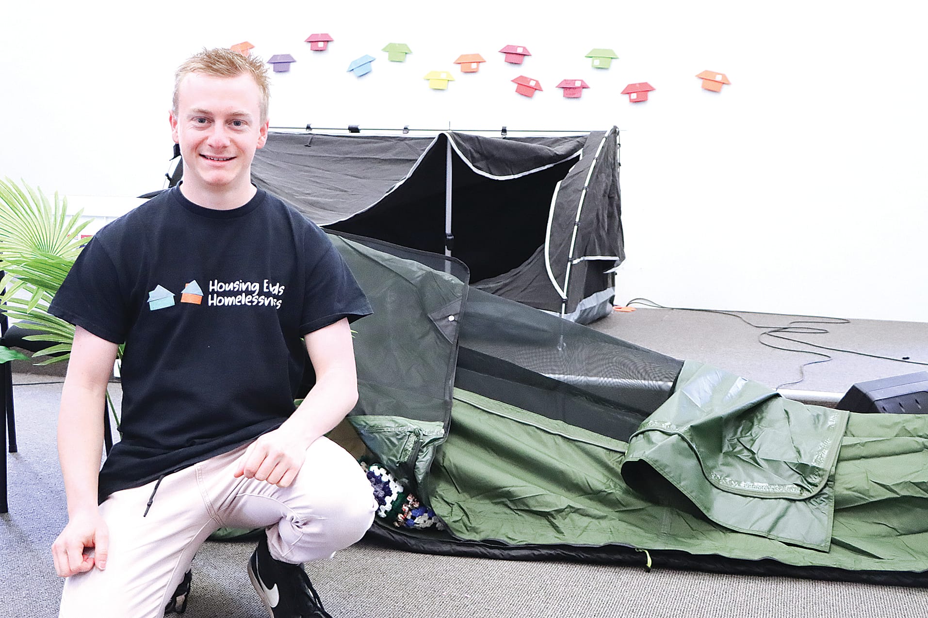 Luke from The Salvation Army homelessness team poses with a swag set up to display one of the ways in which homeless people shelter. A04_3225