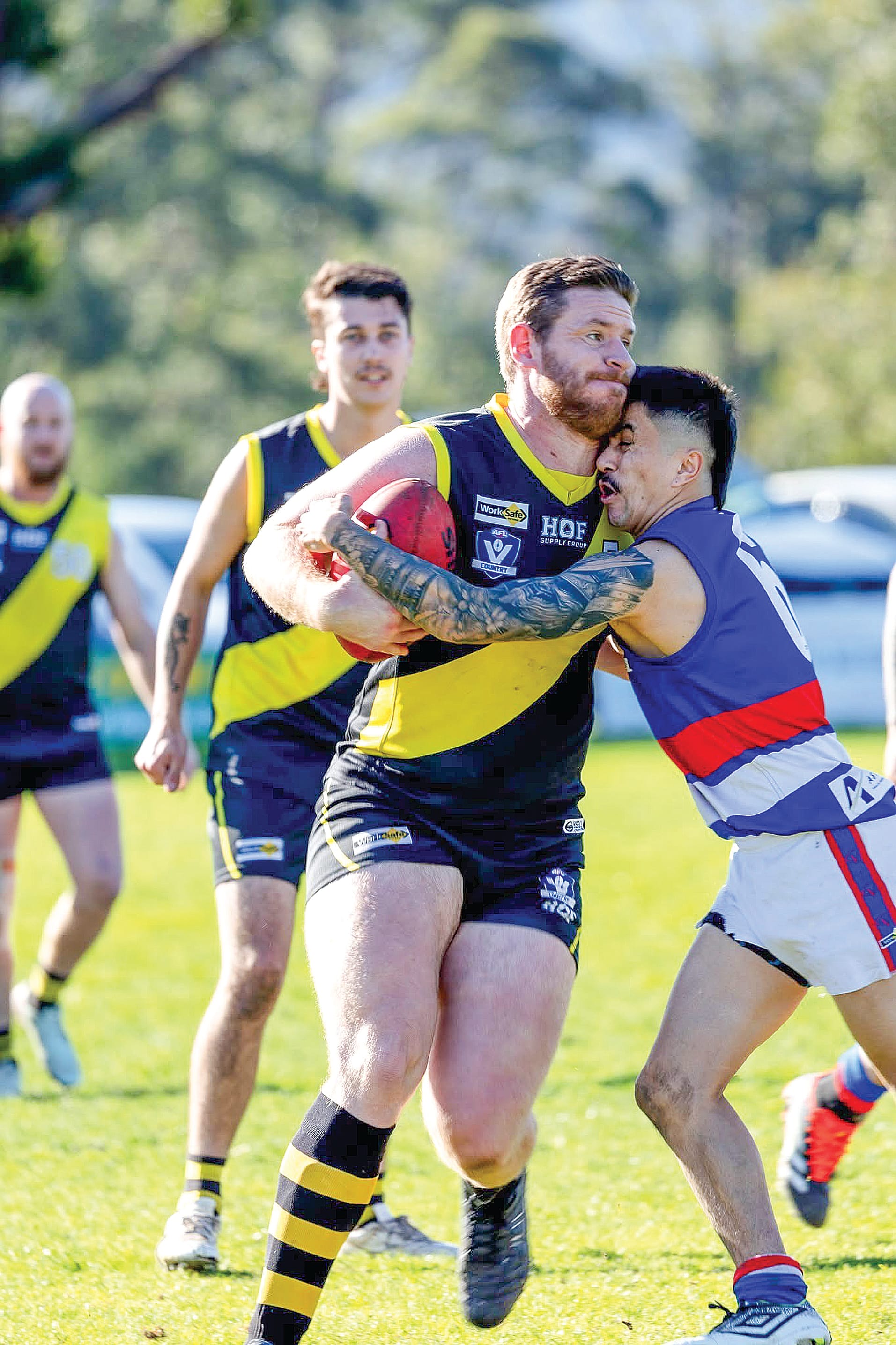 Mirboo North skipper Mitch Richardson tries to escape the clutches of his Newborough opponent during the Tigers’ victory in the Reserves. Photos: Annie Holland.