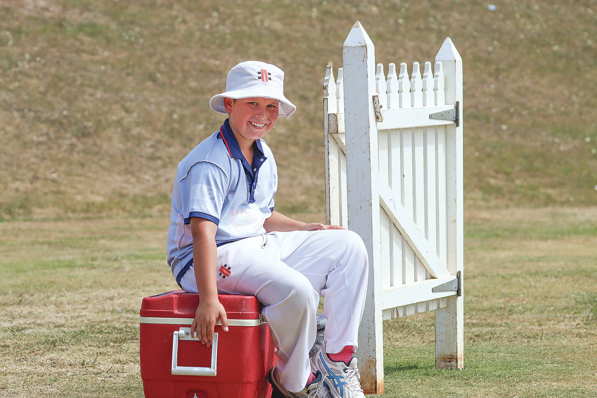 11-year-old Liam Meyer relaxes while waiting to help out Imperials as a substitute fielder. A27_0825