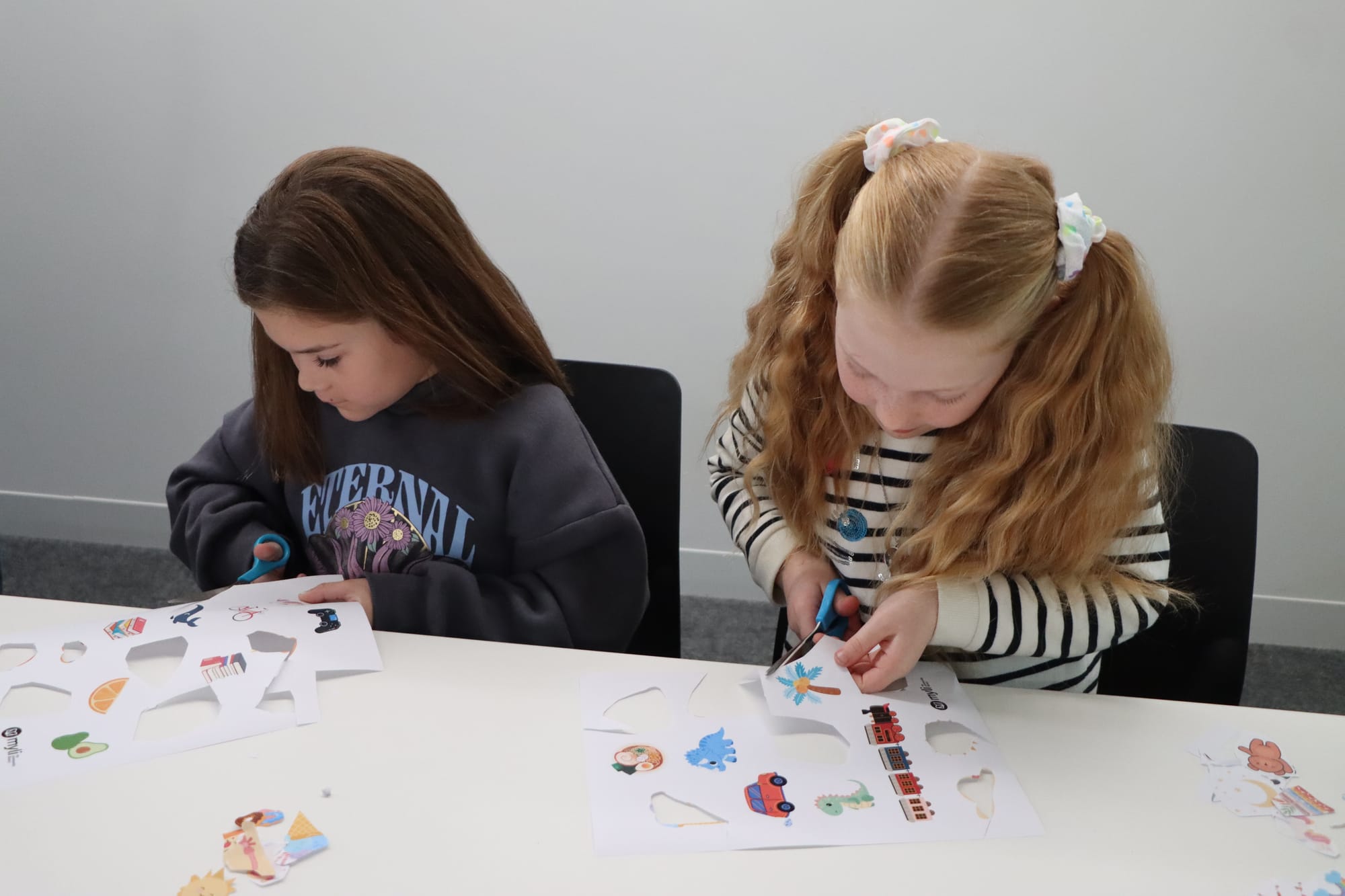 Lily Wyhoon and Charli MacDonald work industriously to create their stickers.