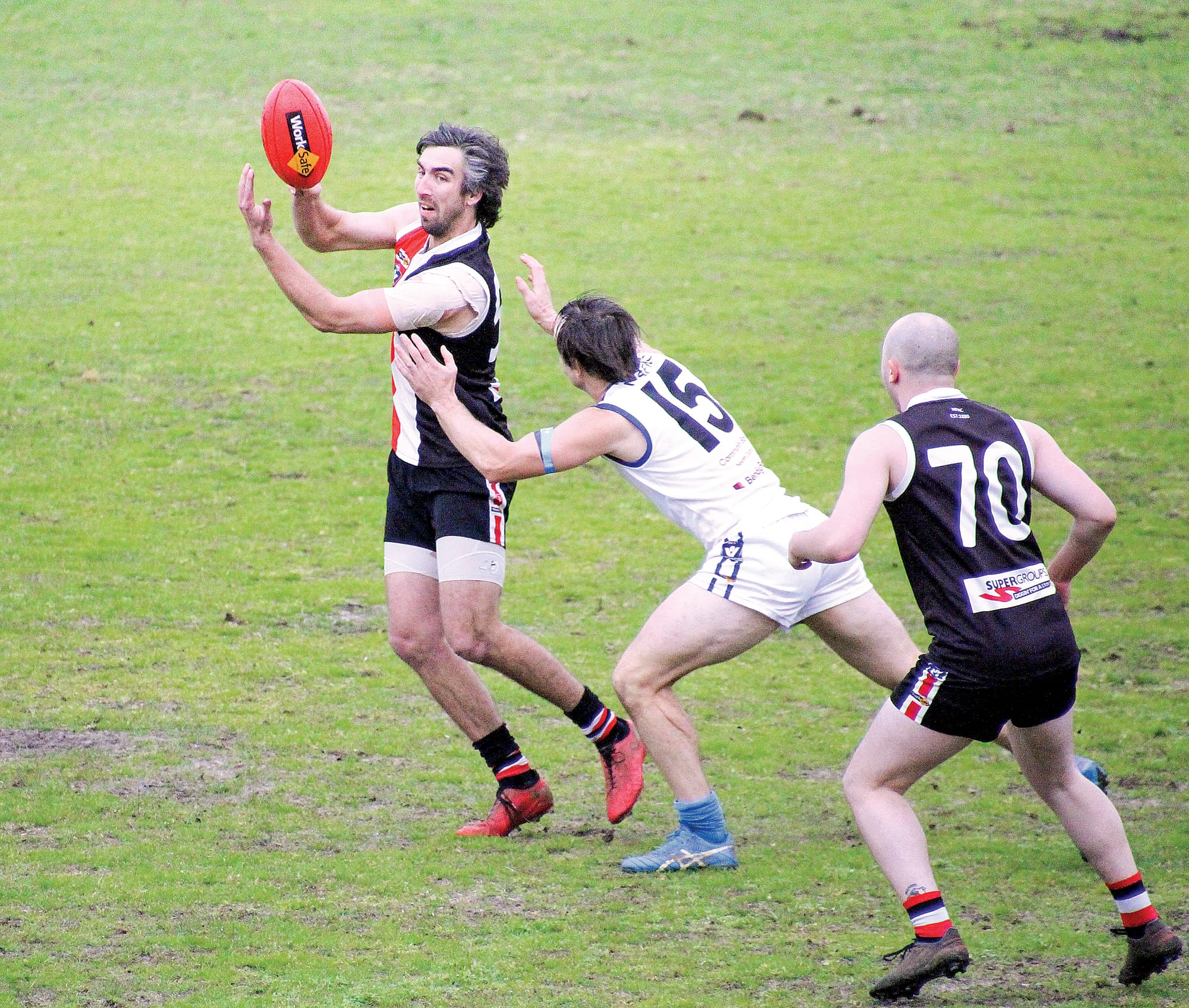 Aidan Simmons gets the handball away under pressure.