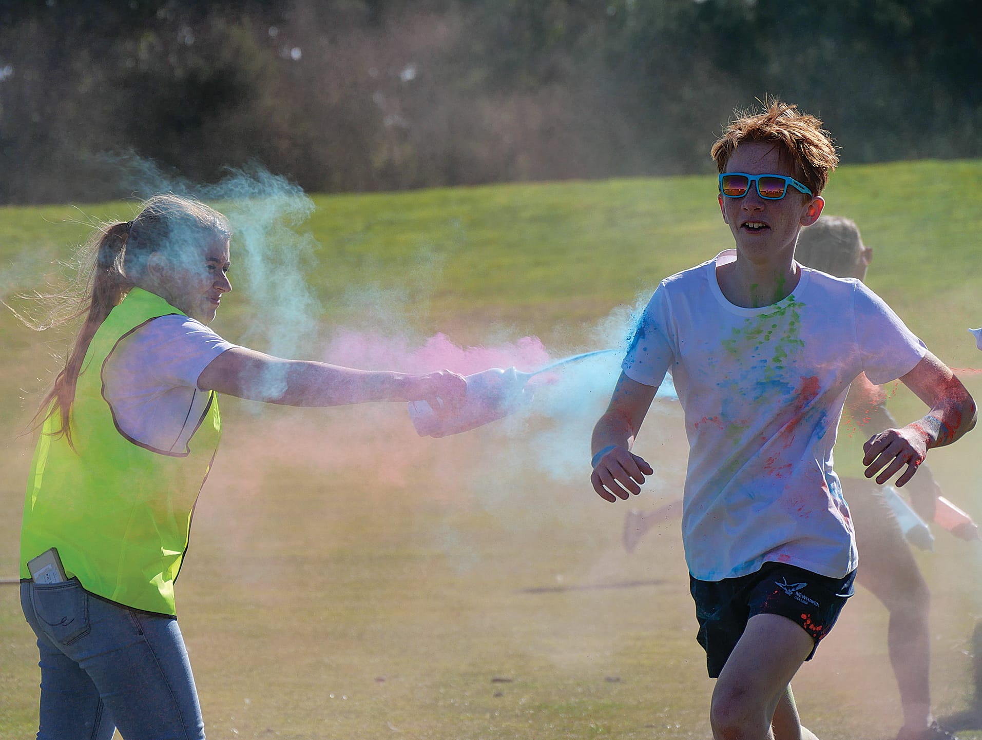 PFA President, Angel Chambers squirts colour dust onto Year 8 student Bede Prideaux.