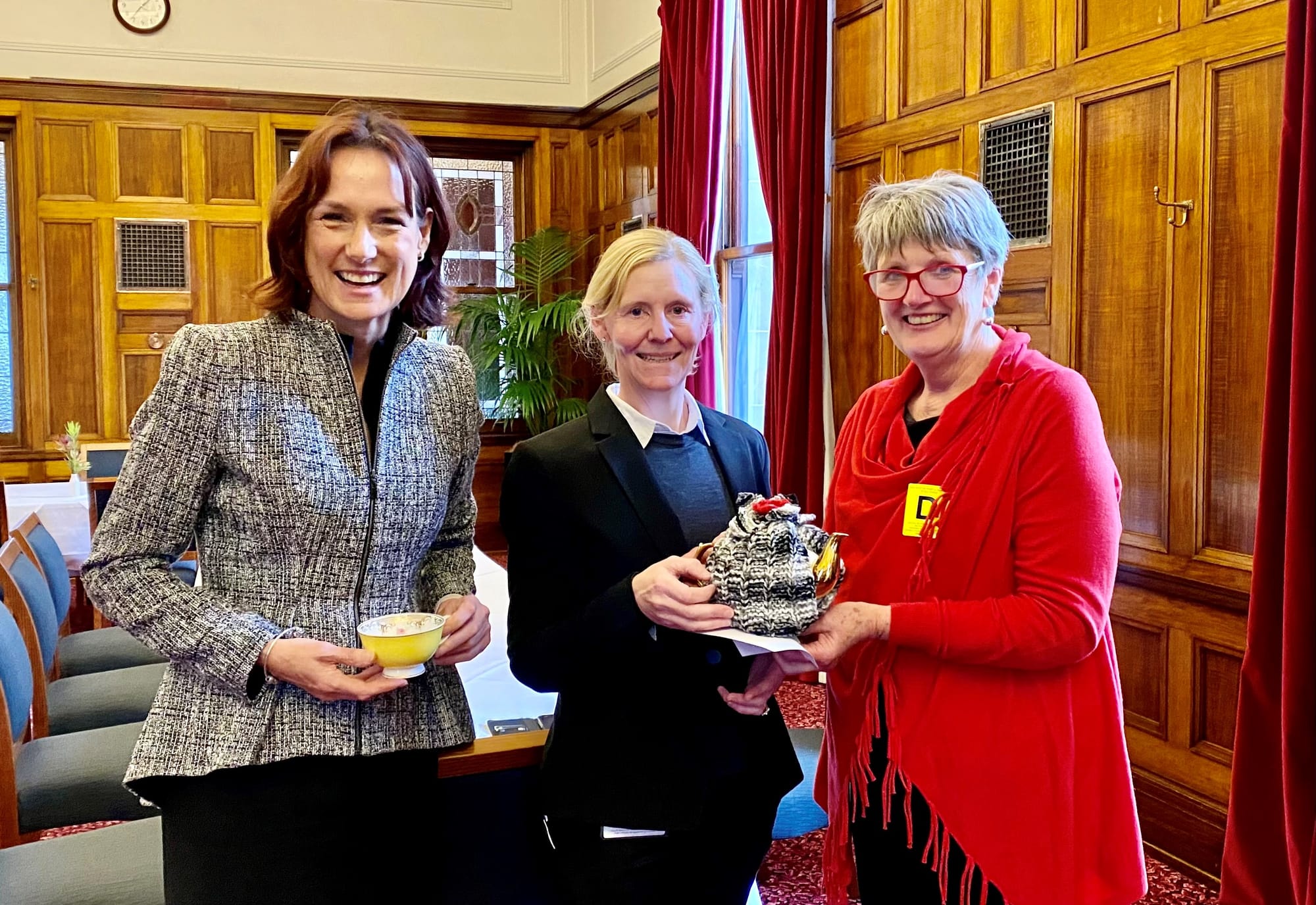 Marge Arnup, President of the Fish creek Tea Cosy Festival, presents Parliament’s catering manager Jacquie Doolan with a touch of Fish Creek, leaving a special tea cosy as a memento of their visit.