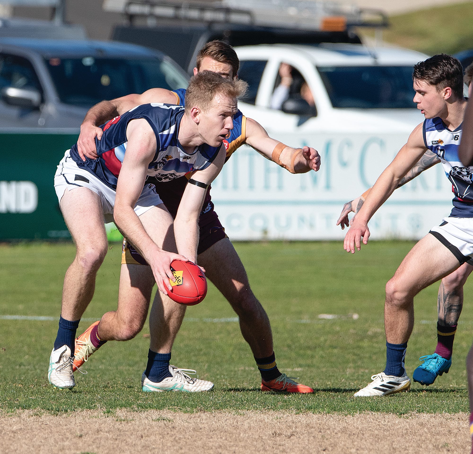 In his 100th senior game for Kilcunda Bass, Sam Watson looks to deliver a safe handball to his teammate. 
