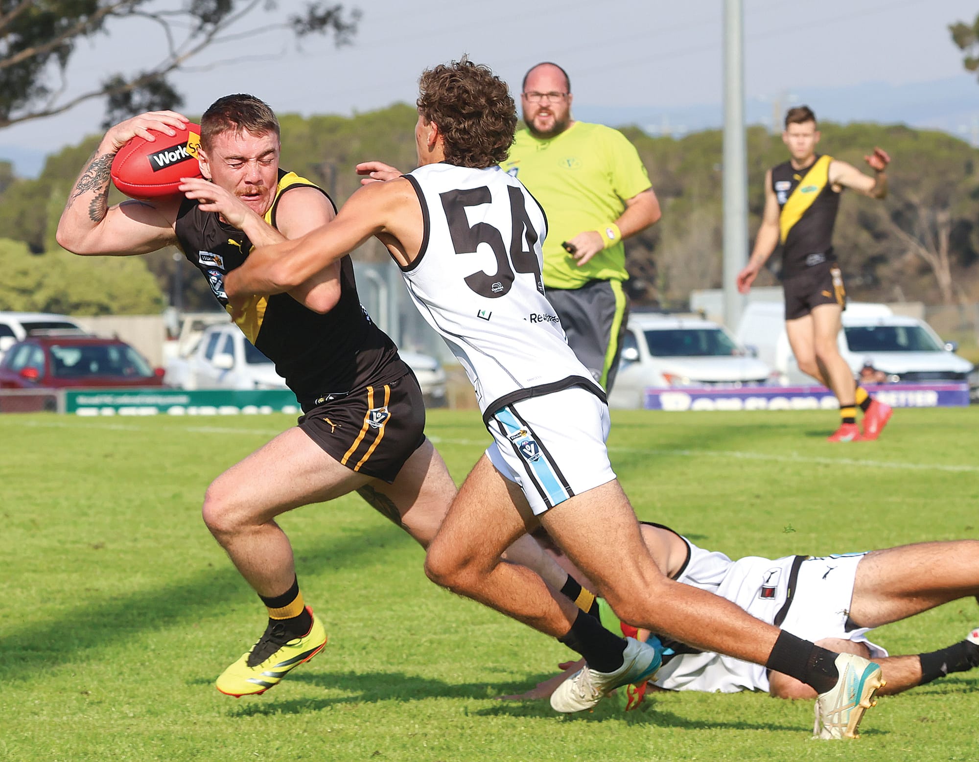 Tom Macmillan of Wonthaggi impedes the progress of Morwell playmaker Brandon Macauliffe at a crucial stage in the last quarter of a thrilling match at Morwell on Saturday.