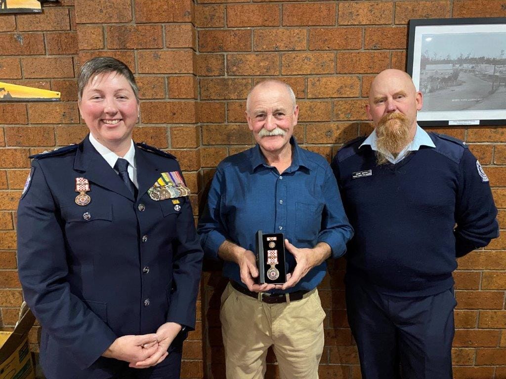 Former Mirboo North and Ruby fire fighter Mark Bourke, now at Berrys Creek, receives his 40-year service award from CFA District 9 Commander Emma Conway and Mirboo North CFA Captain Dave Smith.