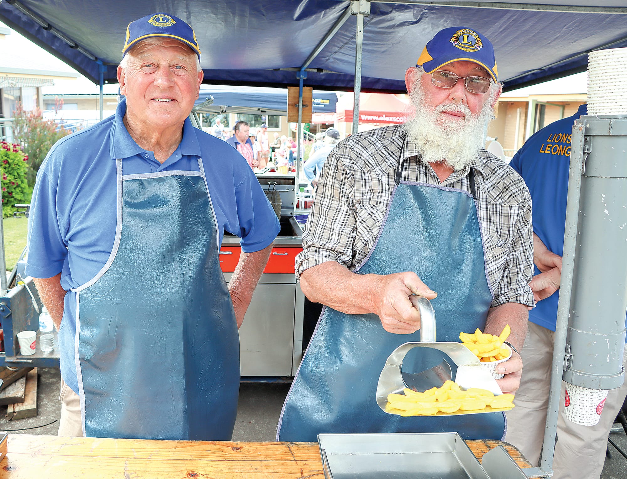 David Thompson and Marius Vandeligt of Leongatha Lions Club serve up golden chips. A07_4823