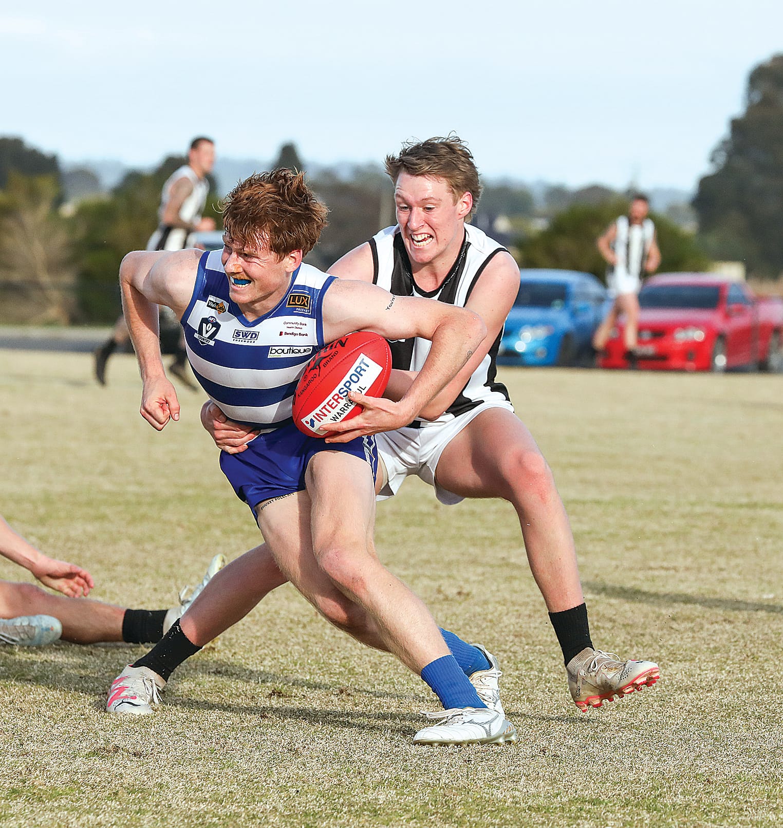 Tommy Burgess fights to give Poowong possession of the ball. 
