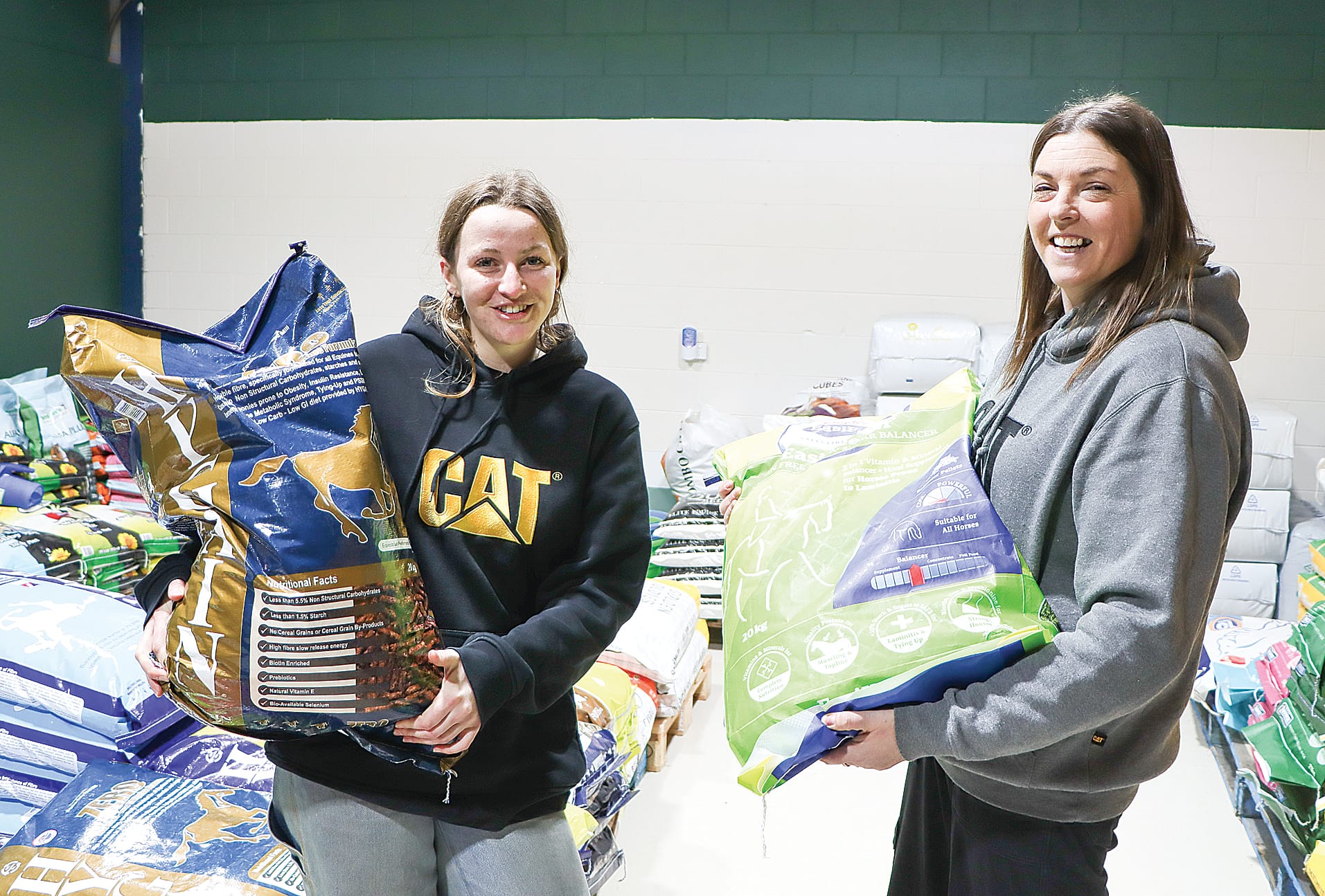 Elispeth McInnes and Kristy Barry show a couple of the horse feed options available at Paws & Ponies. A14_2825