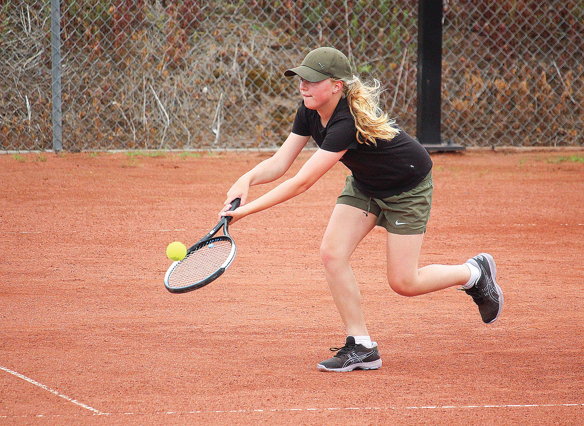 Edie-May Trent of Poowong reaches for a clutch return in her match against Korumburra’s own Ella Skelton. B08_0223
