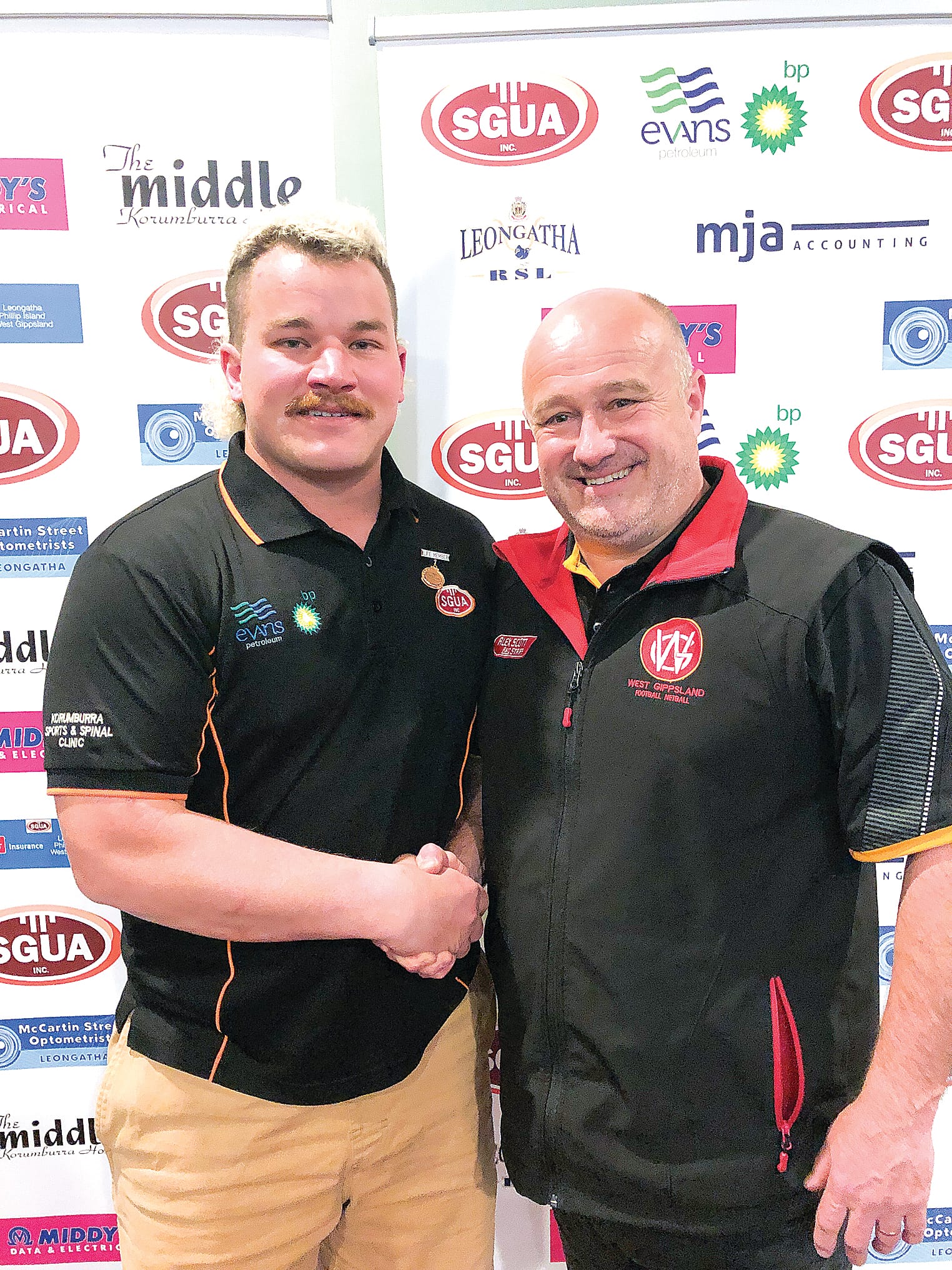 Brett Tessari (right) congratulated Kane Pepperell on receiving the South Gippsland Umpires Association life membership.