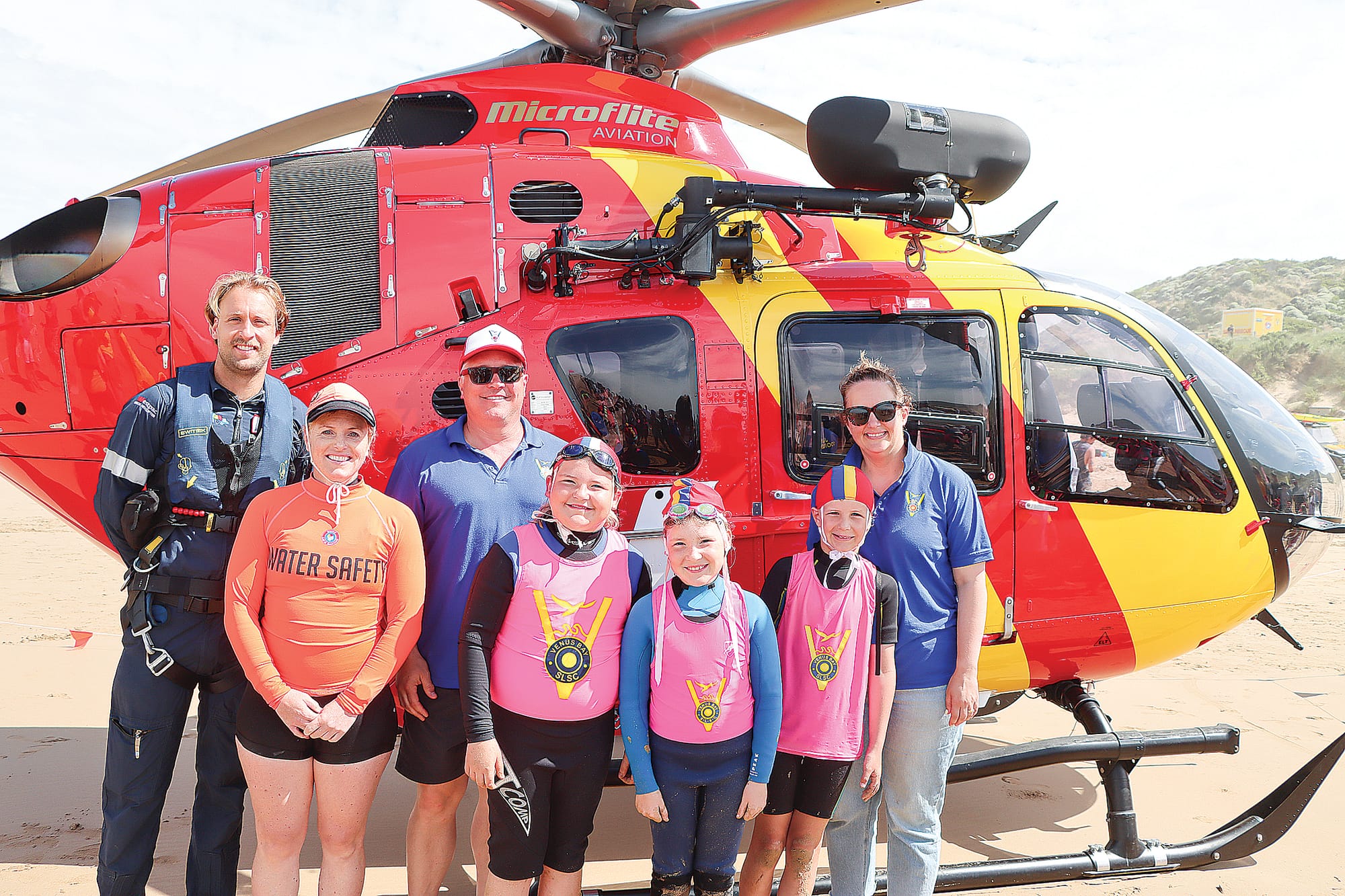 Aircrewman Jack Slykhuis, Venus Bay Surf Life Saving Club president Kimberley Gee, the club’s Director of Nippers Ben Growns, Willow and Eva Growns and Parker and Angela Dawson with the Westpac Rescue chopper. A05_0224