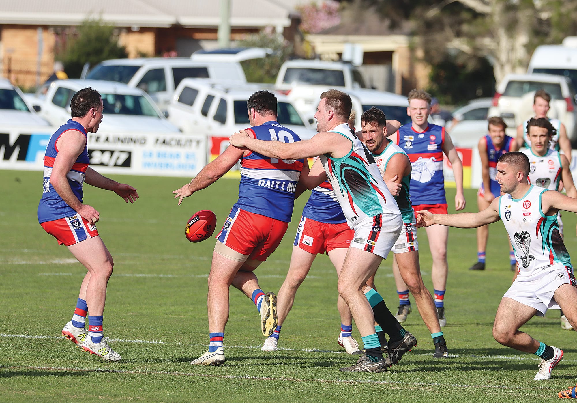 Phillip Island coach Cam Pedersen gets away a kick as his opponent William Thomas prepares to tackle. A32_3625
