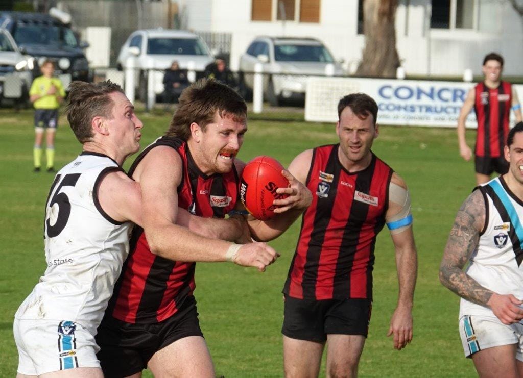 Wonthaggi’s Aiden Lindsay wraps up Maffra’s big ruckman Will Pleming as he tries to break clear of the pack.