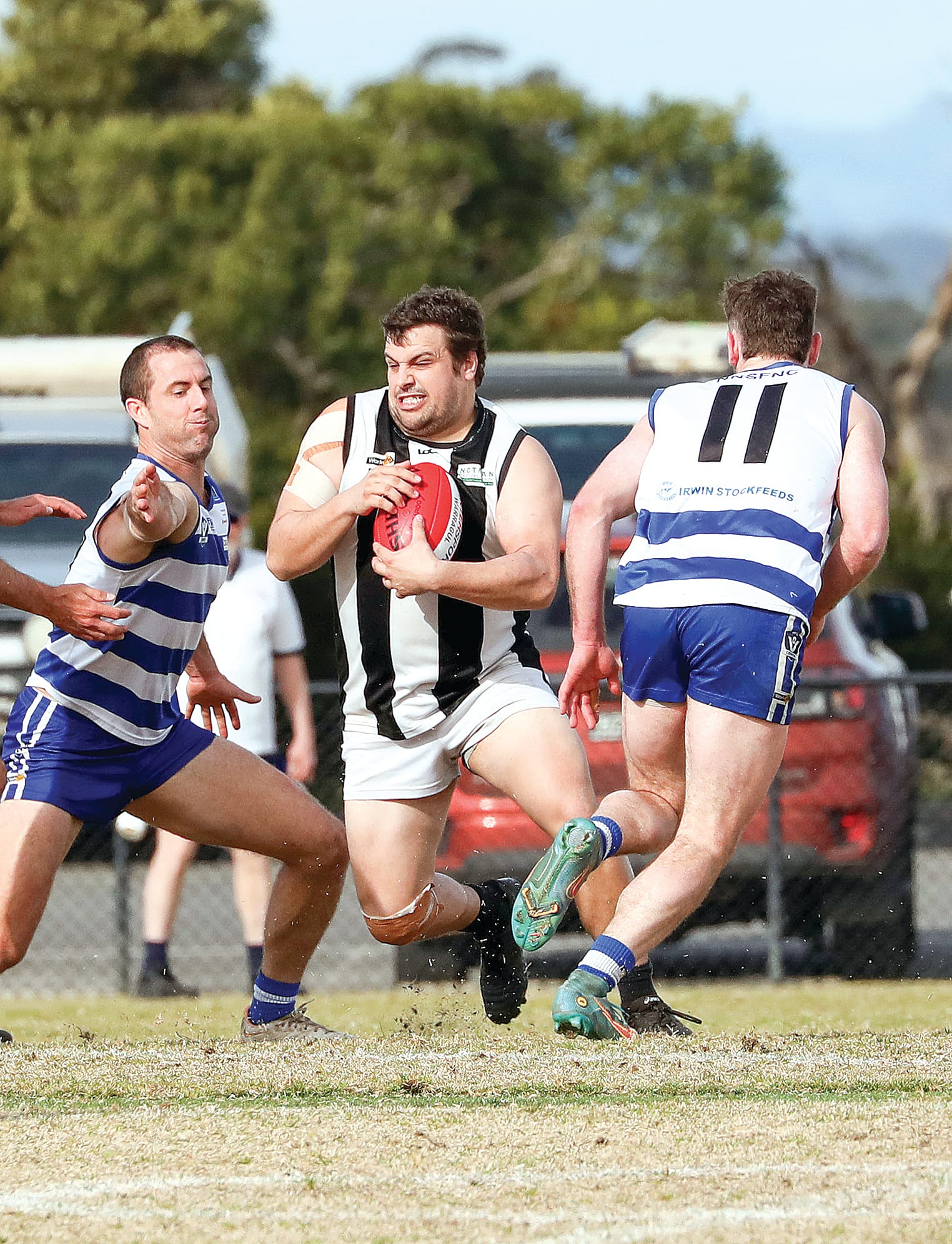Poowong’s Michael Whiting protects the ball through a Neerim South pack.