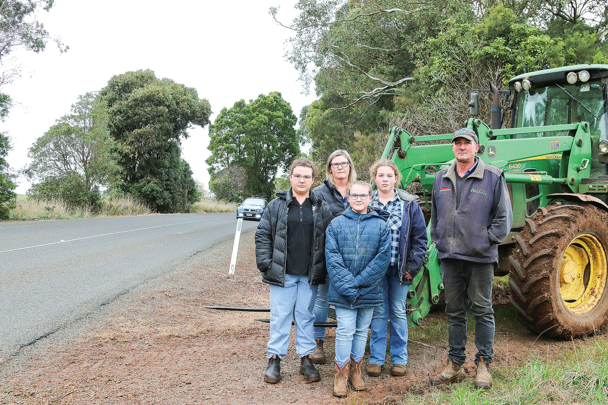 Tayla, Rhonda, Chelsea, Sophie and Warren Lester highlight the dangerous crossing point from Lesters Road across Mardan Road, with a car appearing 
from around the bend. A18_2922