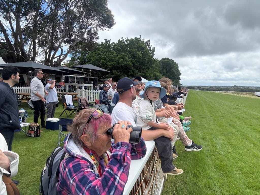 Watching the horses as they start the race on the other side of the course at Woolamai on Saturday.