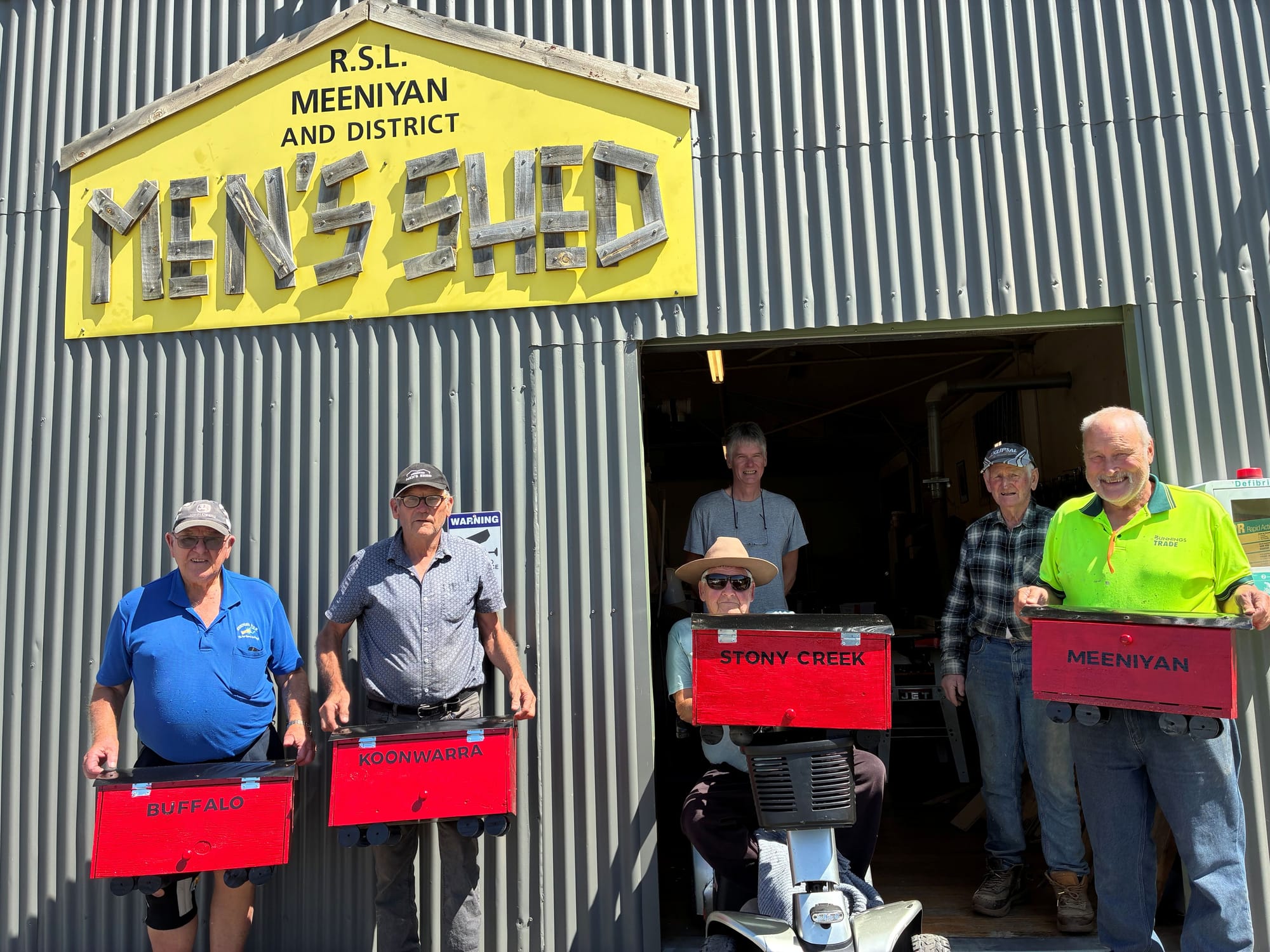 Members of the Meeniyan Men's Shed with the miniature train carriages they built to house the Great Southern Rail Trail passport stamps.