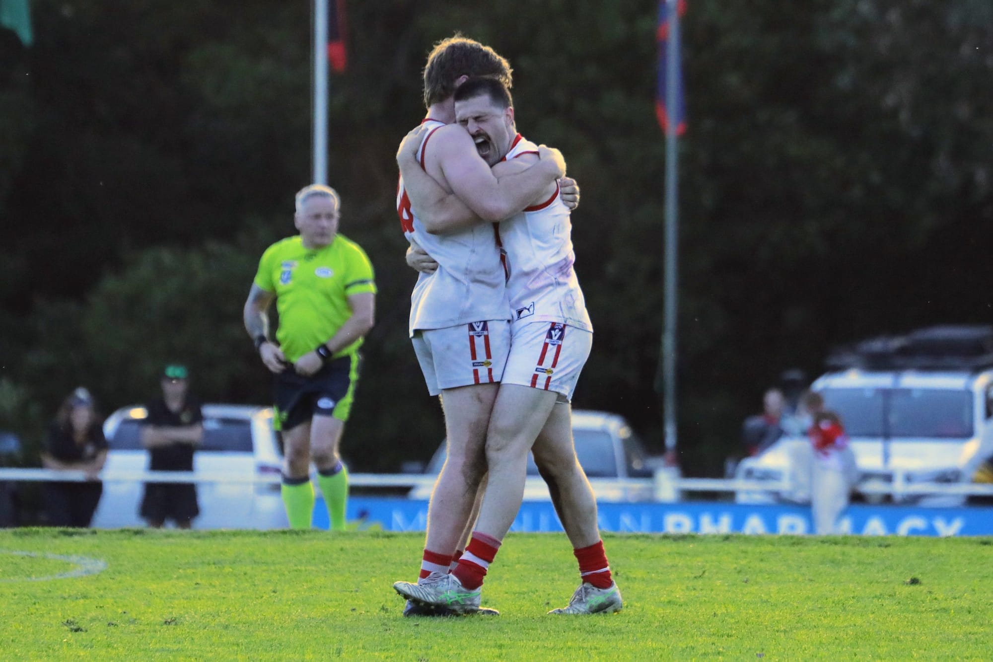 Two Fish Creek players embrace at the final siren