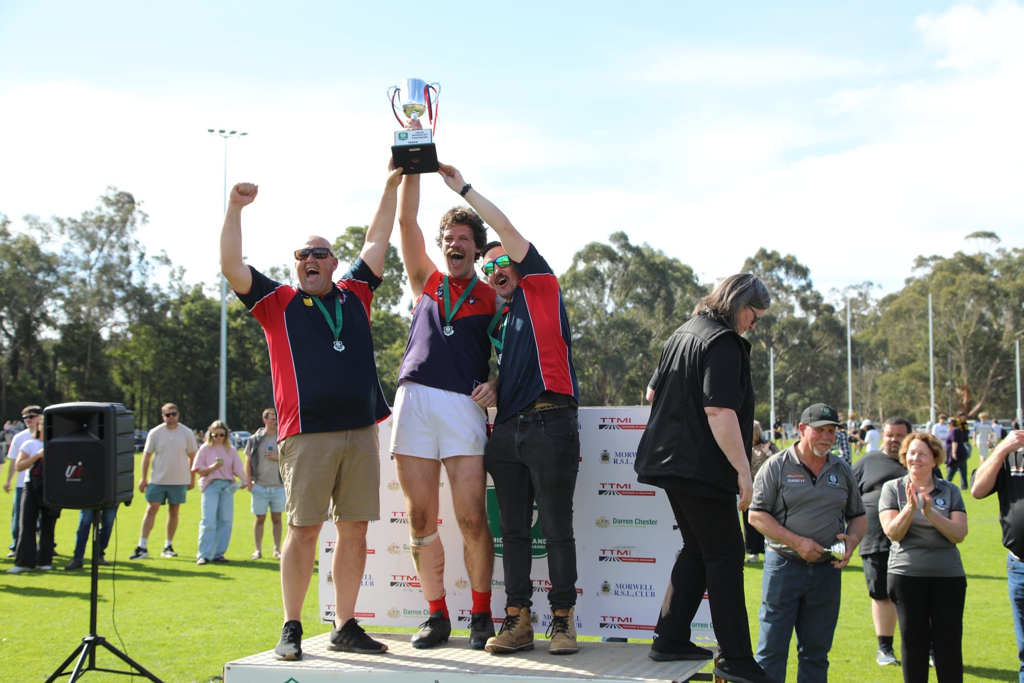 MDU captain and coaches hold the premiership cup aloft