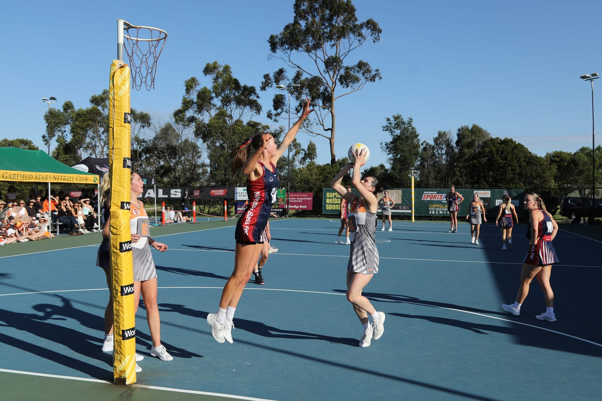 Korumburra Bena goal attack shoots over a defender
