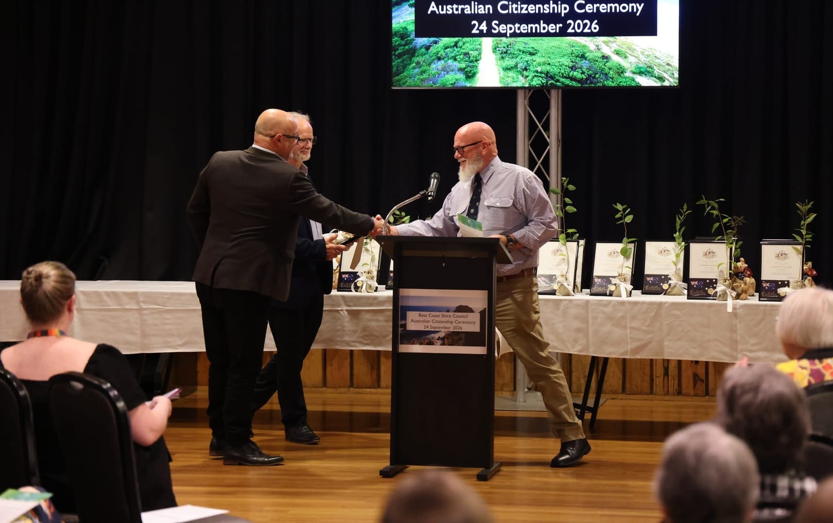 Daniel Hancock receives his certificate and a plant from Mayor Brett Tessari after making his pledge of commitment to Australia.