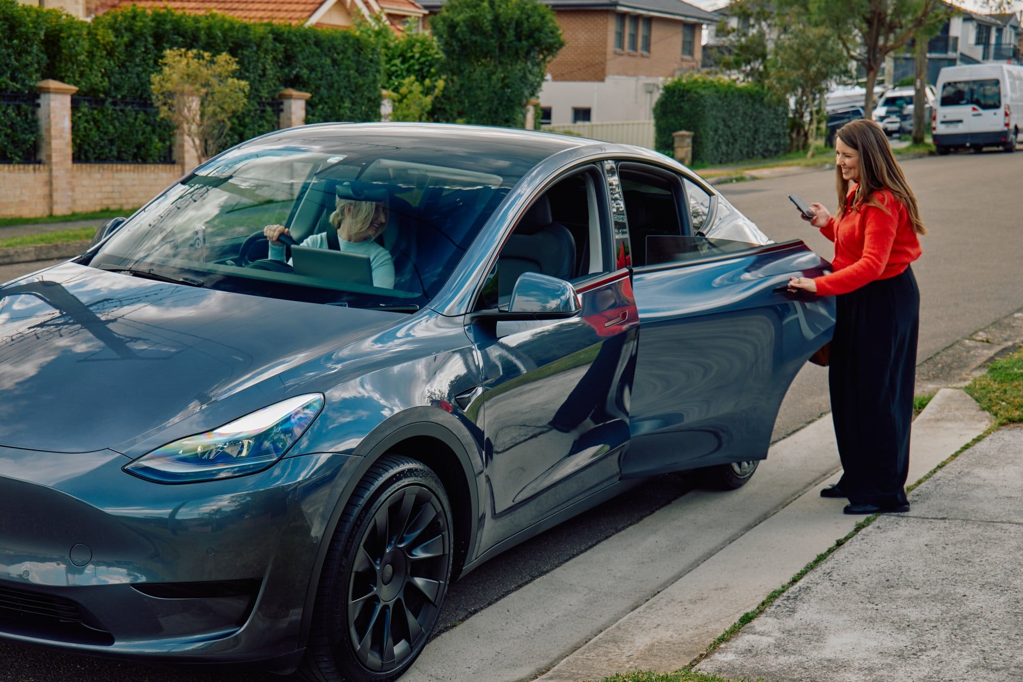 A passenger climbs into an Uber driver partner’s car.