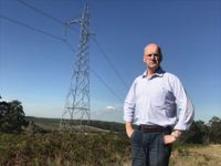 Danny O'Brien standing in front of a transmission tower