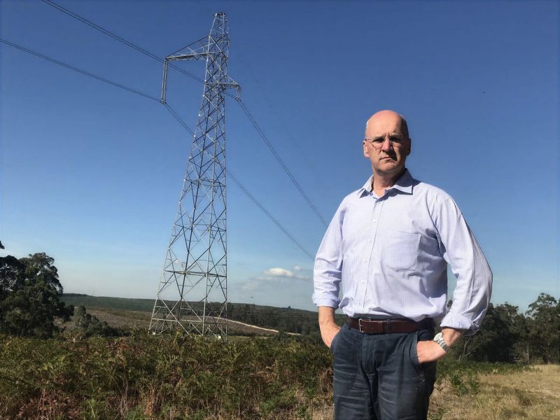 Danny O'Brien standing in front of a transmission tower